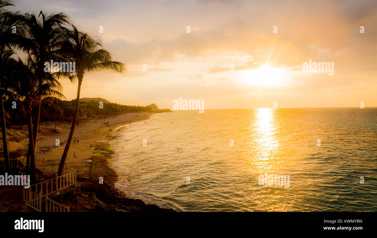 Tramonto su un oceano tropicale e la spiaggia di sabbia con palme in un viaggio e turismo concept Foto Stock