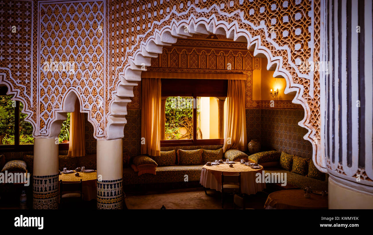 Tabelle di un tradizionale arabo interno illuminato con colonne, gli archi e motivi decorativi Foto Stock