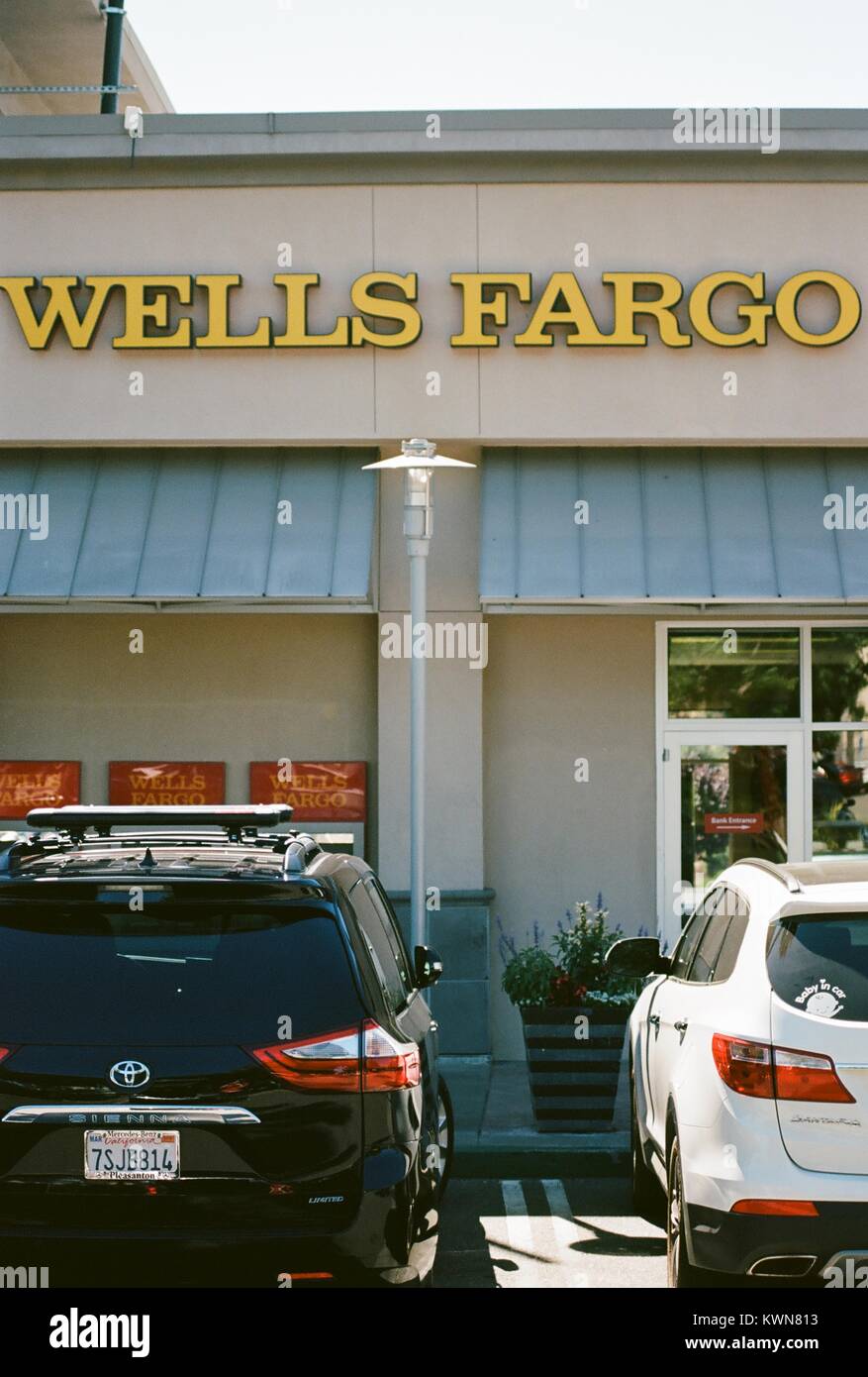 Primo piano della segnaletica, distributori automatici e macchine parcheggiate al di fuori della Banca Wells Fargo Bank branch in San Francisco Bay Area comune di San Ramon, California, 28 giugno 2017. Foto Stock