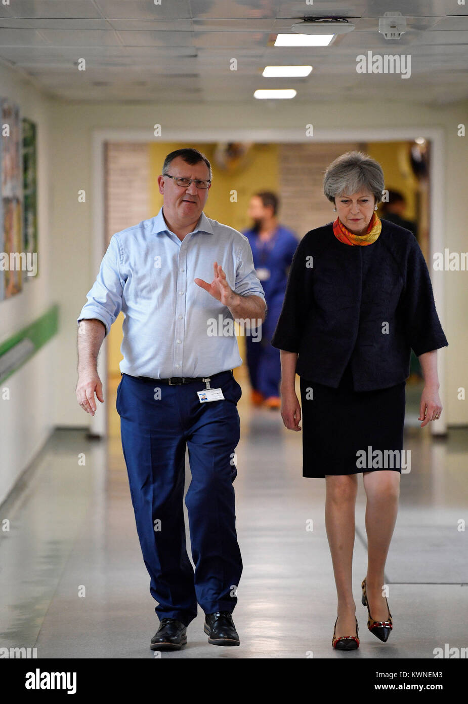 Il primo ministro Theresa Maggio parla di Andrew Morris, CEO di Frimley Health Foundation Trust, come ella visite Frimley Park Hospital vicino a Camberley in Surrey. Foto Stock
