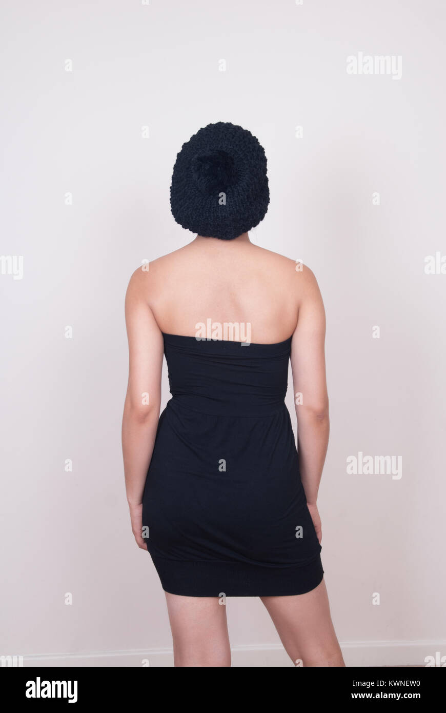 Vista posteriore di una giovane donna che indossa un sleeveless abiti estivi e un cappello di lana Foto Stock