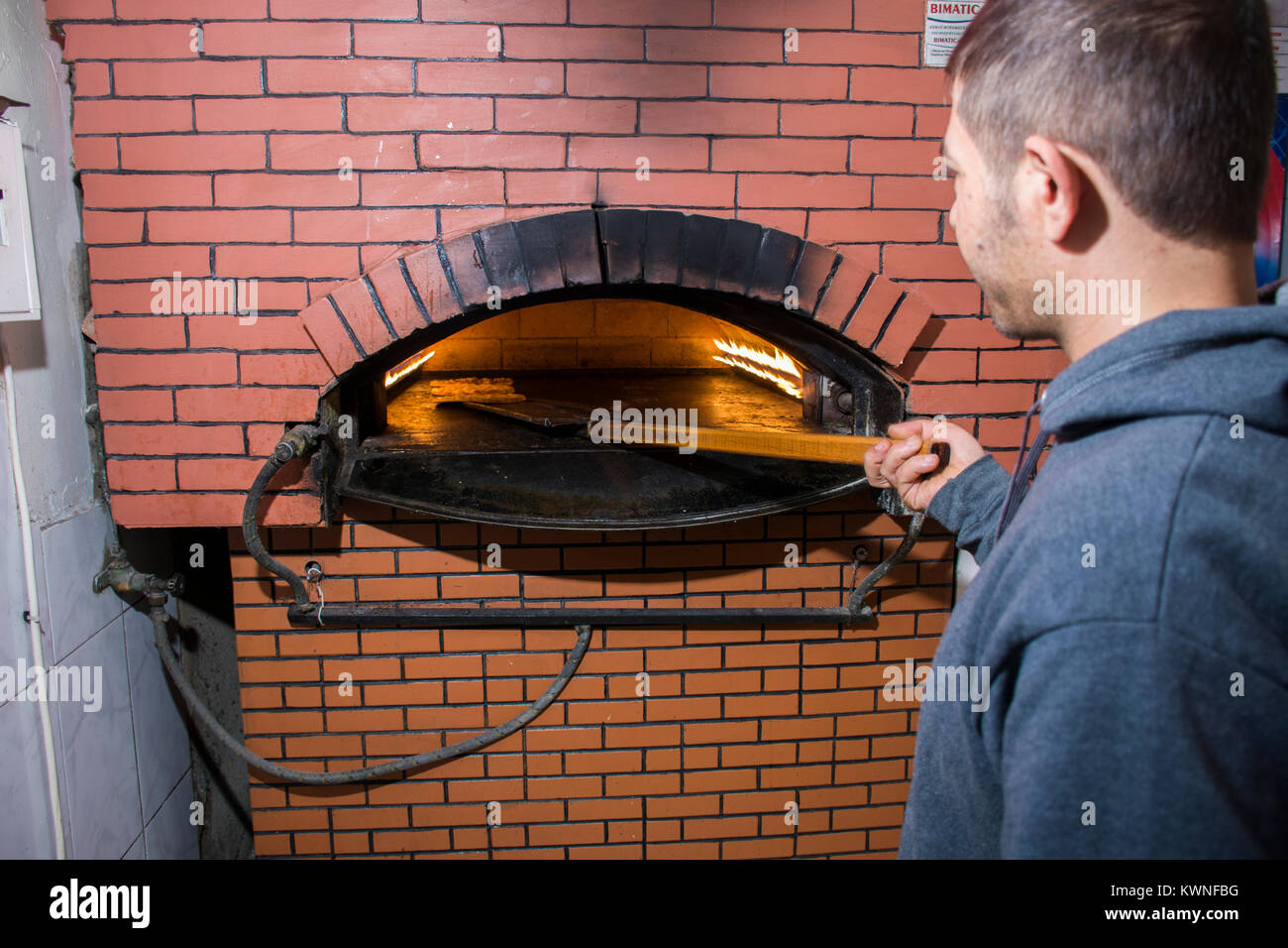 Uomo che lavora all'interno di un forno Foto Stock
