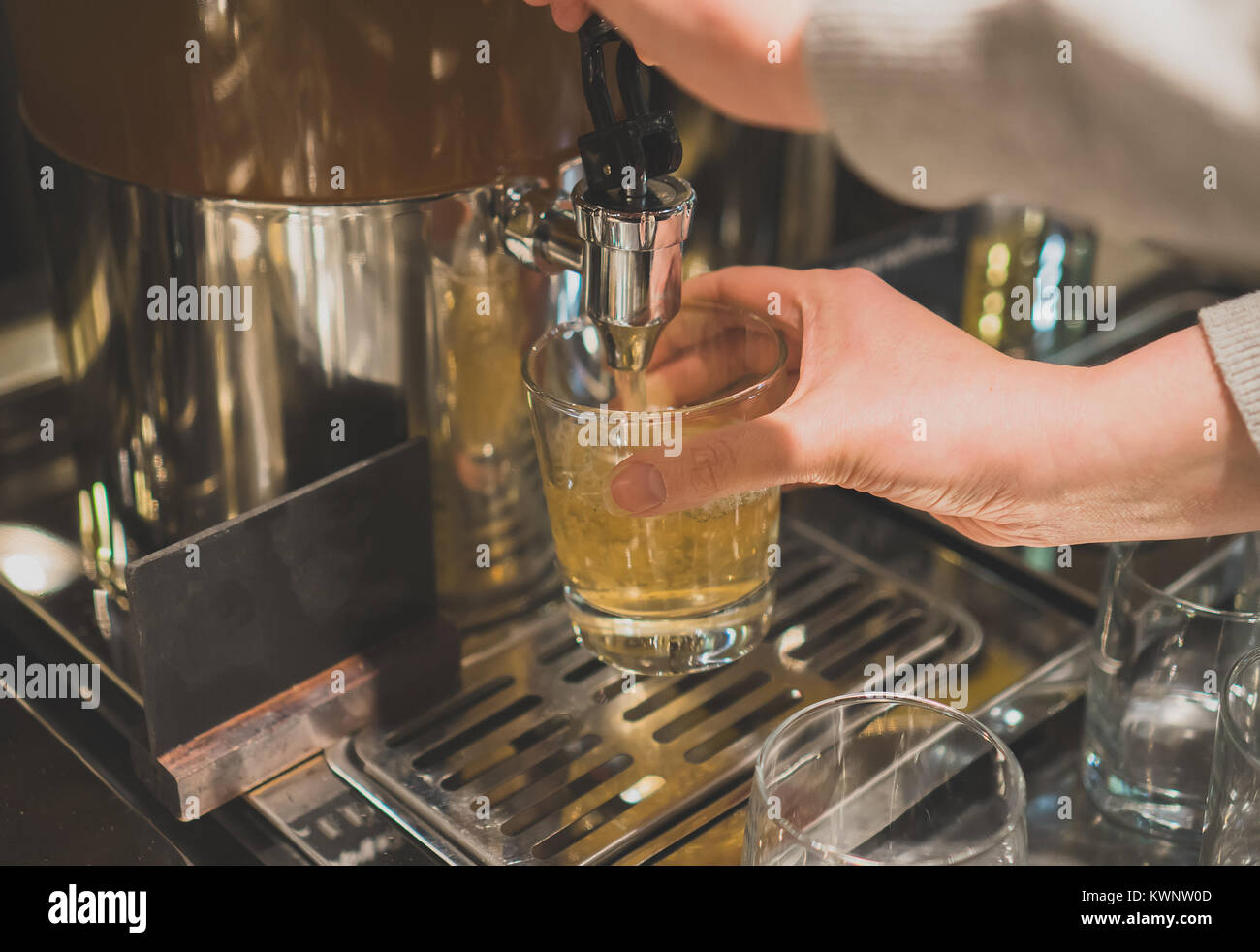 La donna versa un drink nel ristorante con servizio self-service. Foto Stock