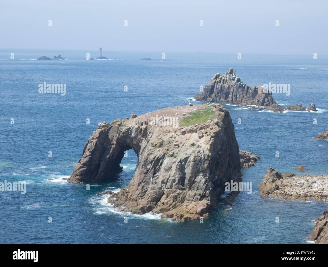 Vista da Carn rallegrare di Enys Dodnan isolotto e Cavaliere armato isolotto in background, penisola di Penwith, Cornwall, Inghilterra, Regno Unito in estate Foto Stock