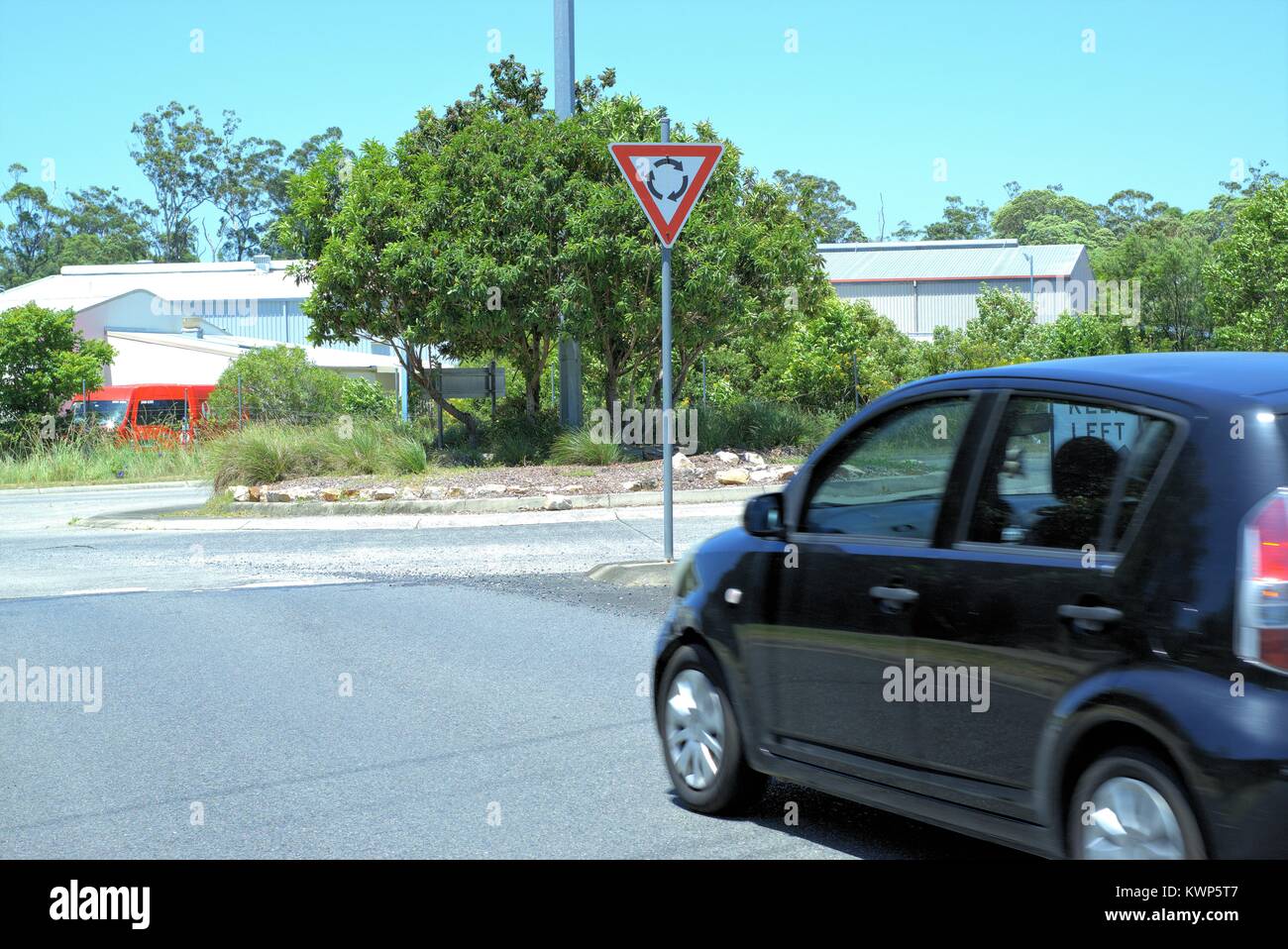 Vettura in movimento alla rotonda in città australiana di Coffs Harbour. Suburban street rotatoria. Foto Stock