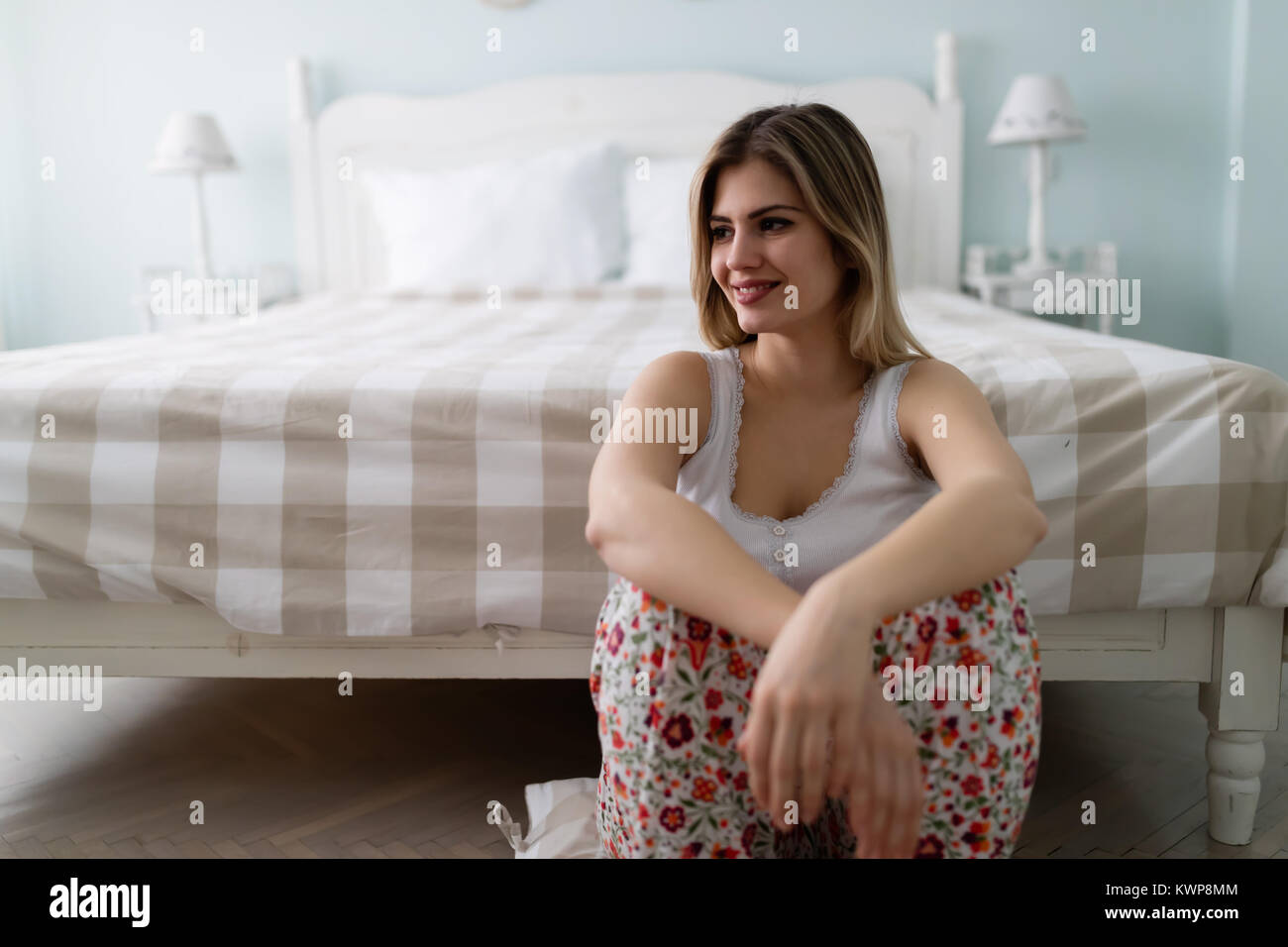 Giovani felici bella donna seduta in camera da letto Foto Stock