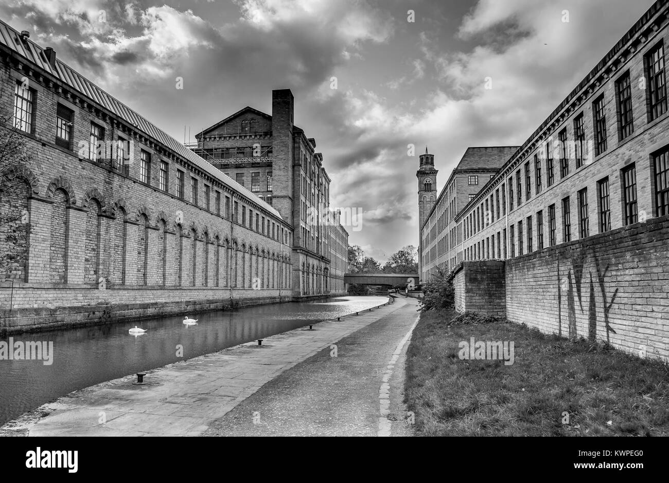 Monocromatico. Salts Mill in Saltaire, un sito del patrimonio mondiale nel West Yorkshire. La Leeds Liverpool canale scorre tra gli edifici. Foto Stock