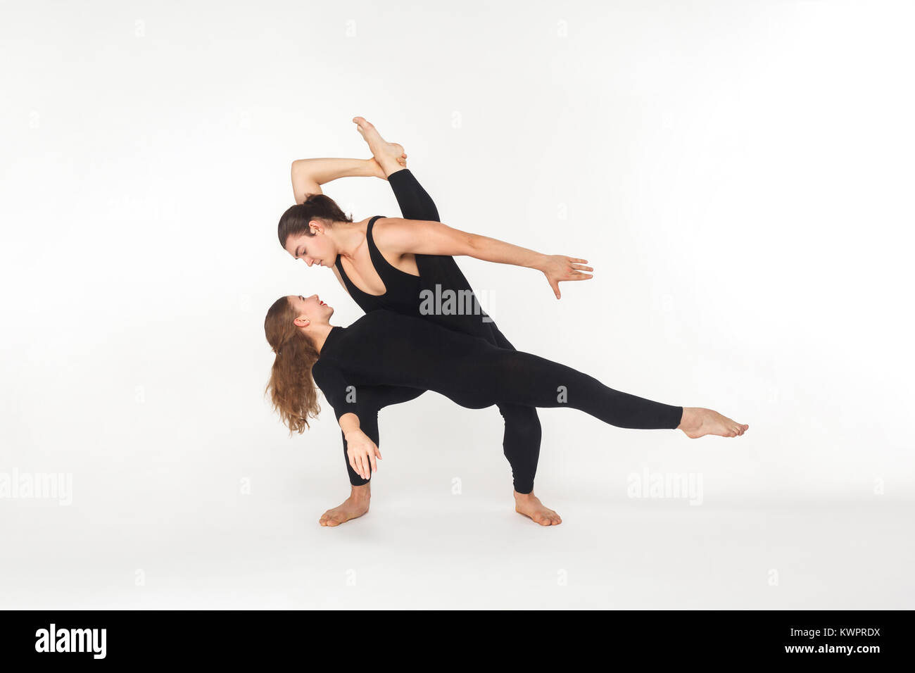 Flessibilità di due amici ballare, facendo le prestazioni. Studio shot, isolato su sfondo bianco Foto Stock