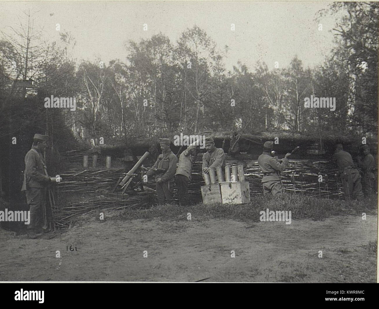 Questa immagine in bianco e nero mostra un mortaio tedesco WW i classificato come Minenwerfer schierato dalla K.u.k 11th Korps-Truppen-Division, posizionato in un deposito scavato con cassette di munizioni nelle vicinanze. Foto Stock