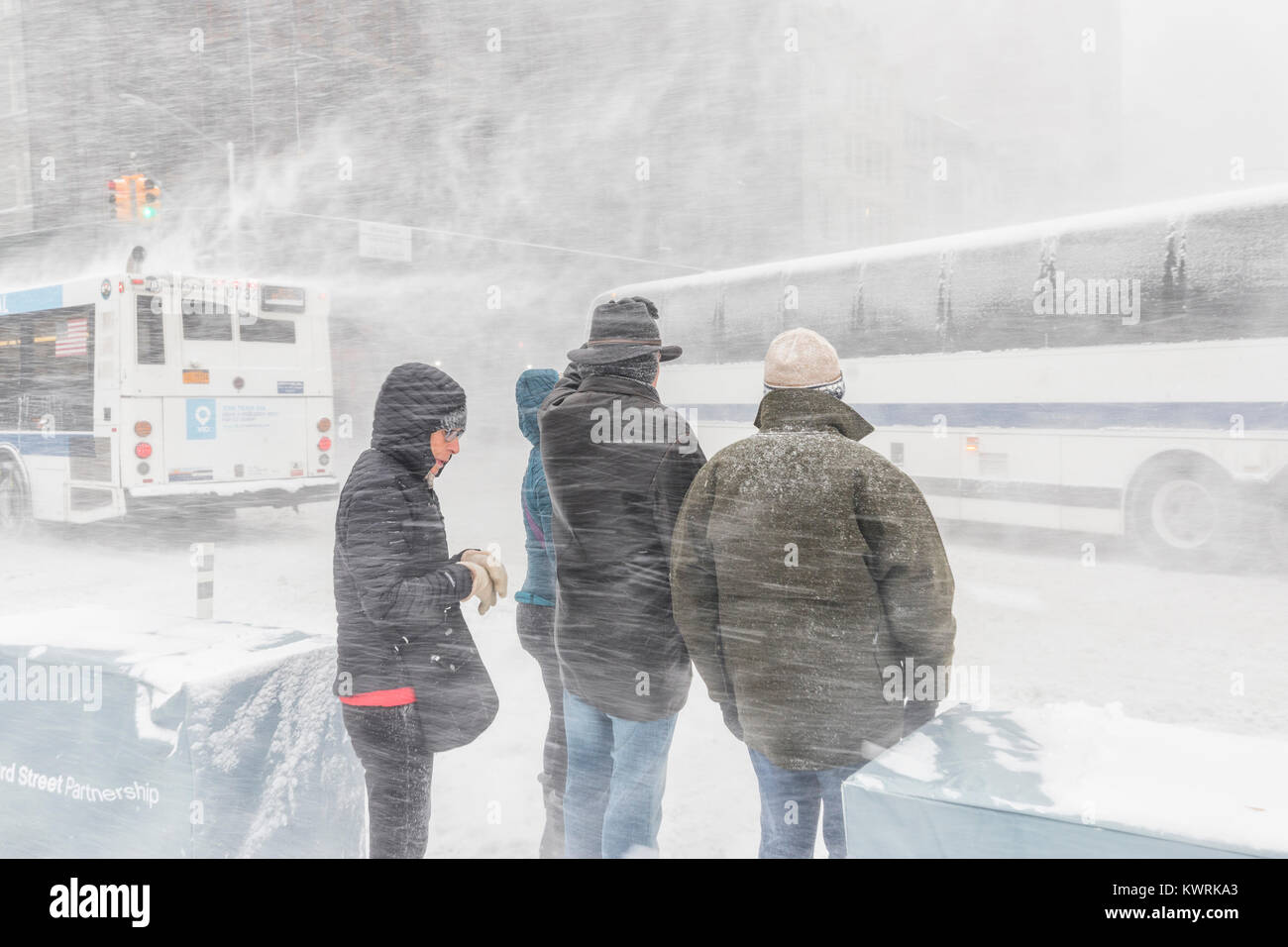 New York, Stati Uniti d'America. 4 gennaio, 2018. Le persone in attesa di attraversare la strada al heawy neve e vento molto forte vicino Flatyron edificio sulla Fifth Avenue; giovedì 4 gennaio 2018 Credit: Nino Marcutti/Alamy Live News Foto Stock