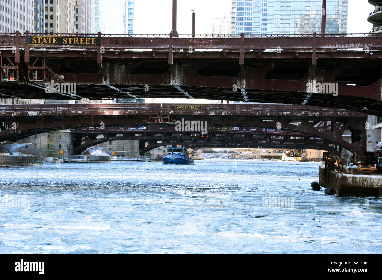 Un rimorchiatore che lavora per rompere il ghiaccio sul fiume per tenerlo aperto al traffico commerciale nel centro di Chicago come gennaio temperature tuffo. Foto Stock
