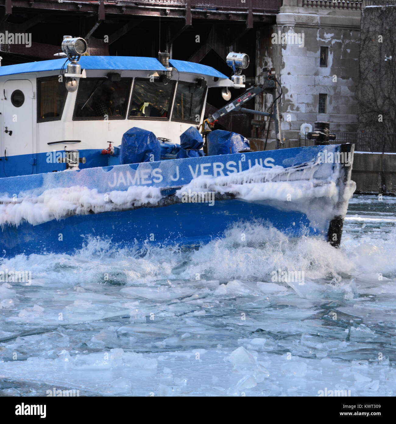 Un rimorchiatore che lavora per rompere il ghiaccio sul fiume per tenerlo aperto al traffico commerciale nel centro di Chicago come gennaio temperature tuffo. Foto Stock