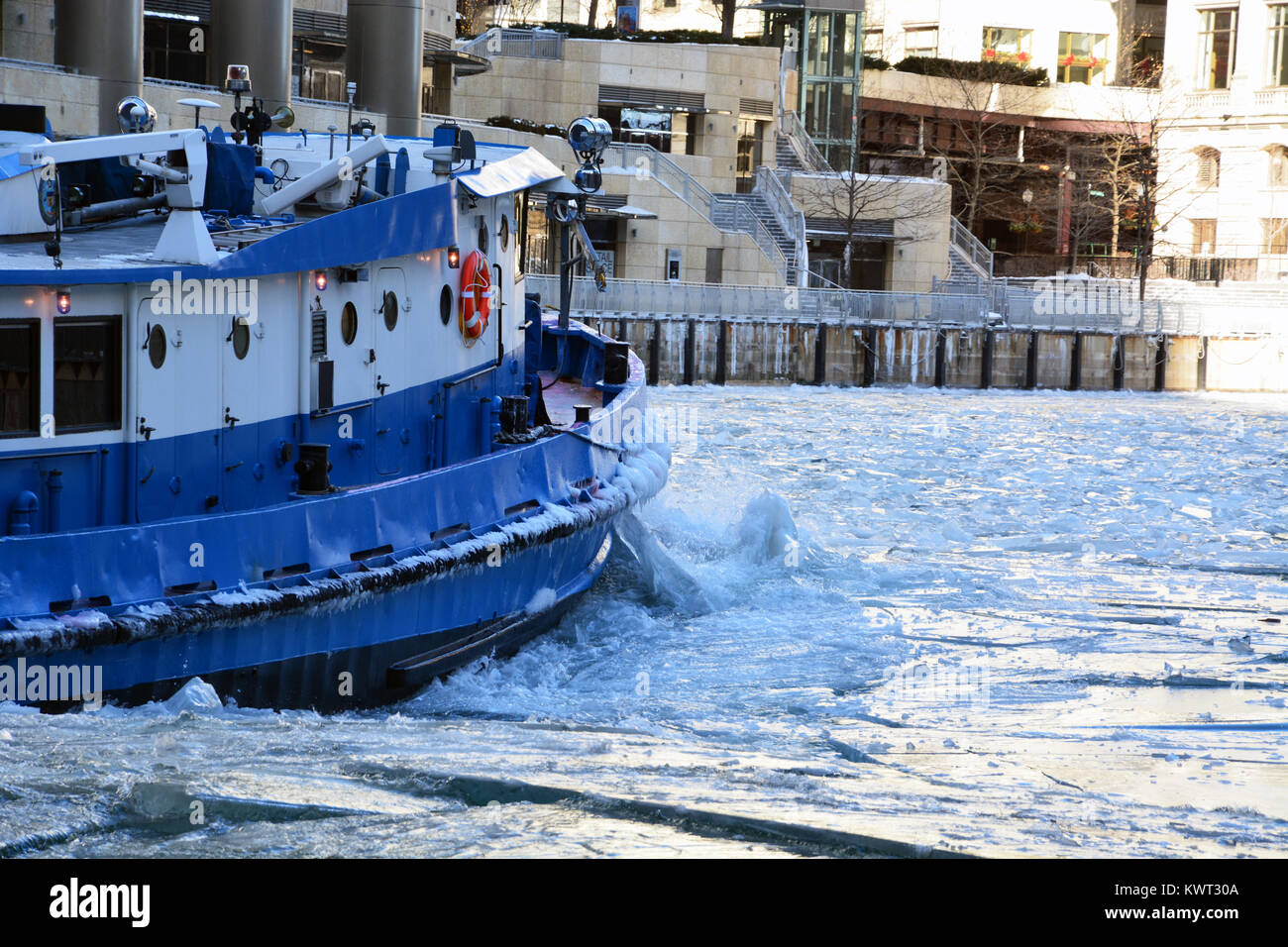 Un rimorchiatore che lavora per rompere il ghiaccio sul fiume per tenerlo aperto al traffico commerciale nel centro di Chicago come gennaio temperature tuffo. Foto Stock