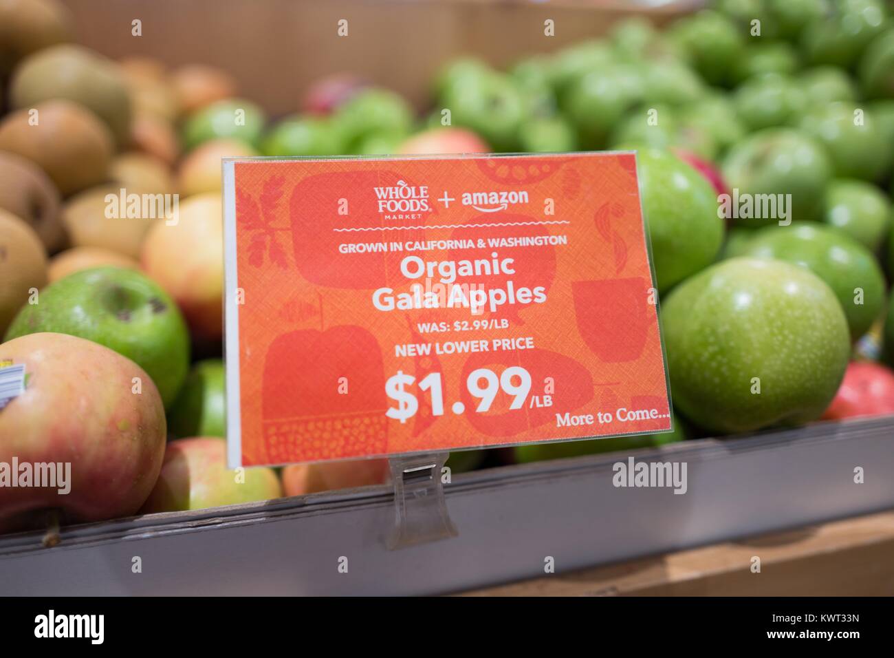 Insegne su un display di mele Gala a Whole Foods Market Store di San Ramon,  California la lettura "Whole Foods Market e Amazon, nuovo prezzo più basso,  più a venire", annunciando Whole