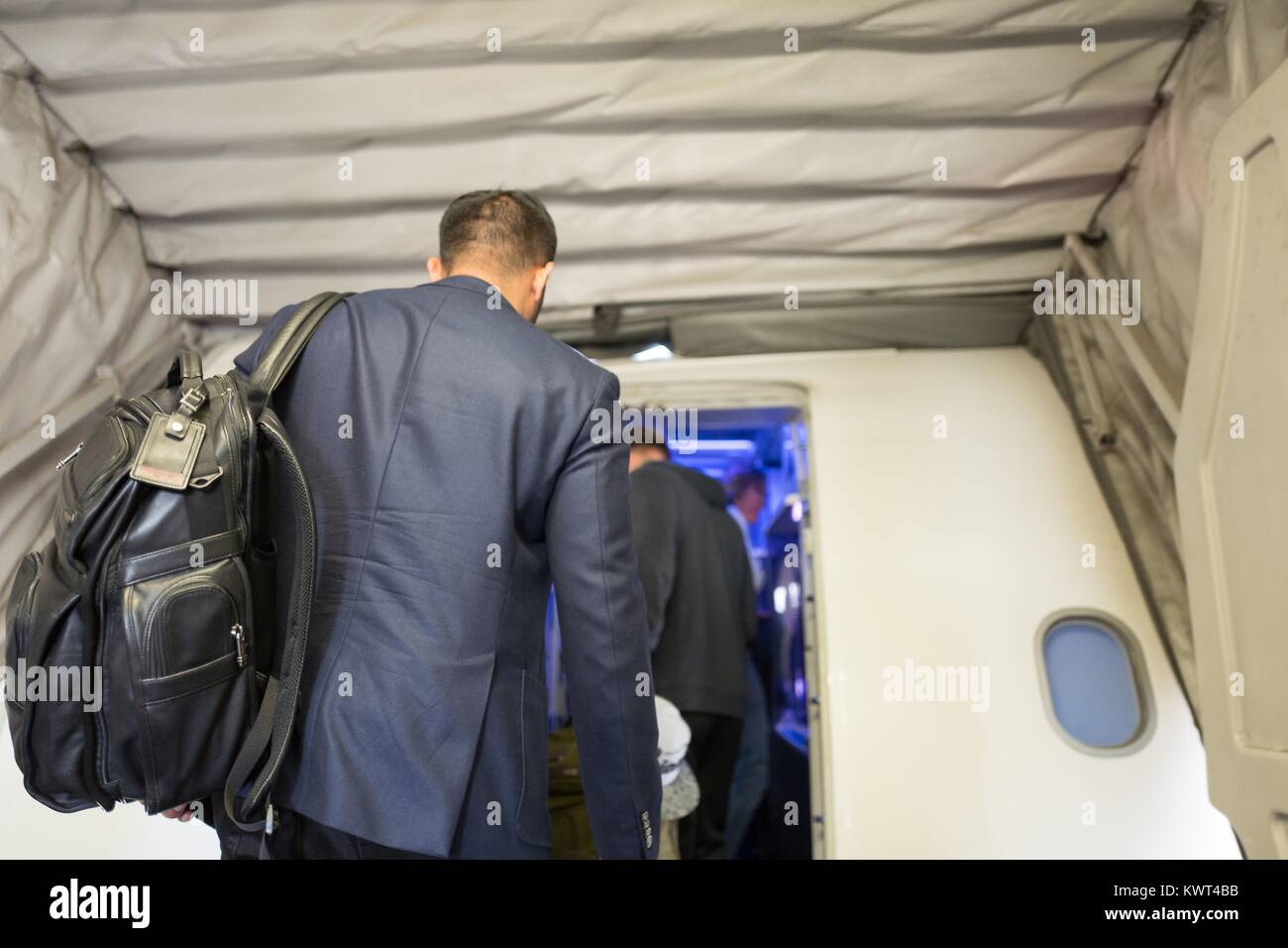Un imprenditore che indossa una tuta e portante una valigia Tumi si prepara a bordo di una Virgin America aereo all'Aeroporto Internazionale di San Francisco (SFO), San Francisco, California, 13 settembre 2017. Foto Stock