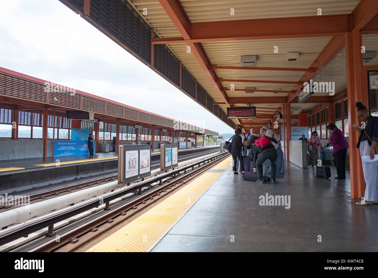 I piloti di linea e attendere per un treno per San Francisco all'Walnut Creek, California stazione della Bay Area Rapid Transit (BART) Sistema ferroviario leggero, 13 settembre 2017. Foto Stock