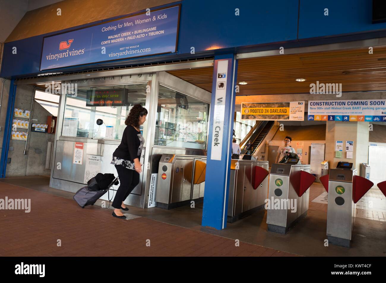 Una donna che porta una valigia entra i tornelli al Bay Area Rapid Transit (BART) stazione di Walnut Creek, California, 13 settembre 2017. Foto Stock