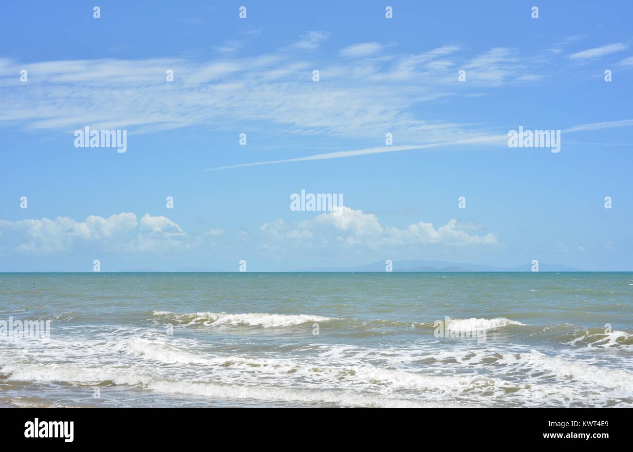 Piccole onde a laminazione a una spiaggia con un cielo azzurro, Bagal spiaggia vicino a Townsville, Queensland, Australia Foto Stock