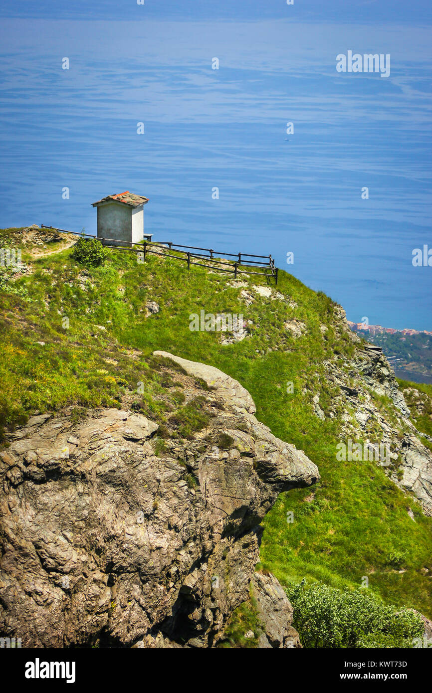 Paesaggio alpino con piccolo monumento di soldati di fronte al Mar Mediterraneo nella nazionale del Beigua Geopark, Liguria, Italia Foto Stock