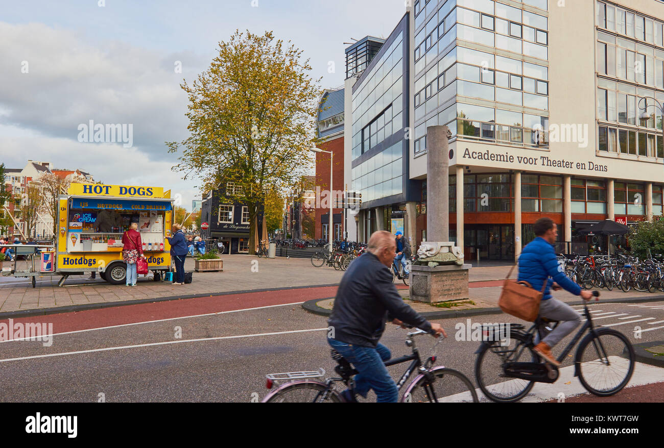 Biciclette e un hot dog stand vicino all'Accademia per il teatro e la danza (Academie Voor Theatre en Dans), Jodenbreestraat, Amsterdam, Paesi Bassi Foto Stock