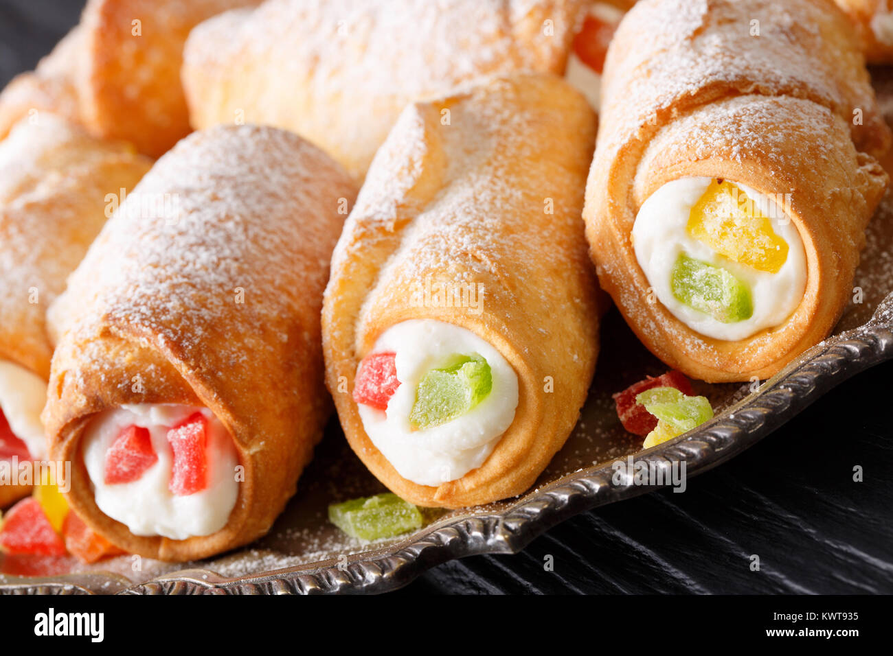 Cannoli italiano dolce con una delicata crema al formaggio close-up su una piastra orizzontale. Foto Stock