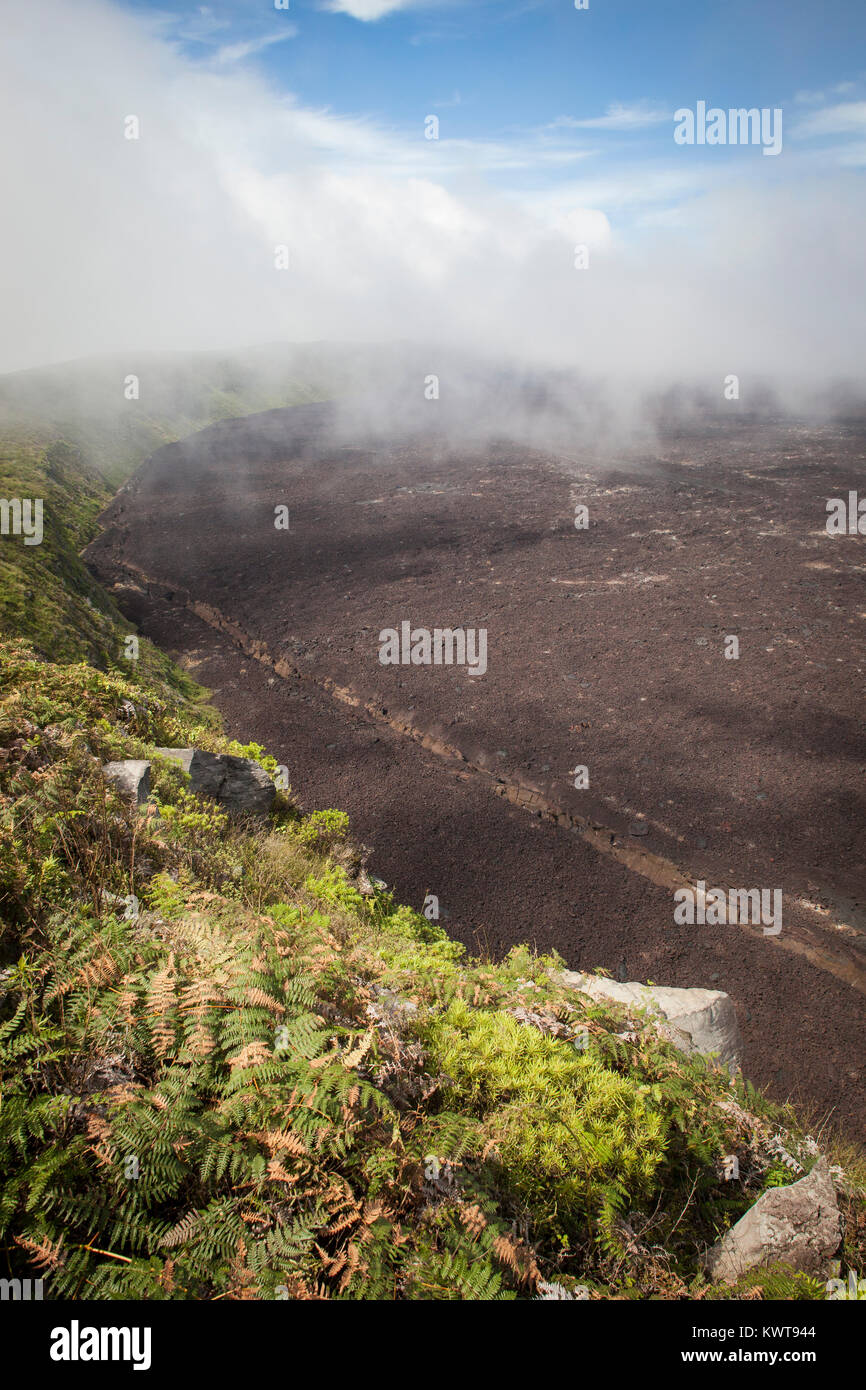 Nuvole roll in alla sommità del vulcano Sierra Negra. Il fiume di lava-coperto caldera è visibile al di sotto. Foto Stock