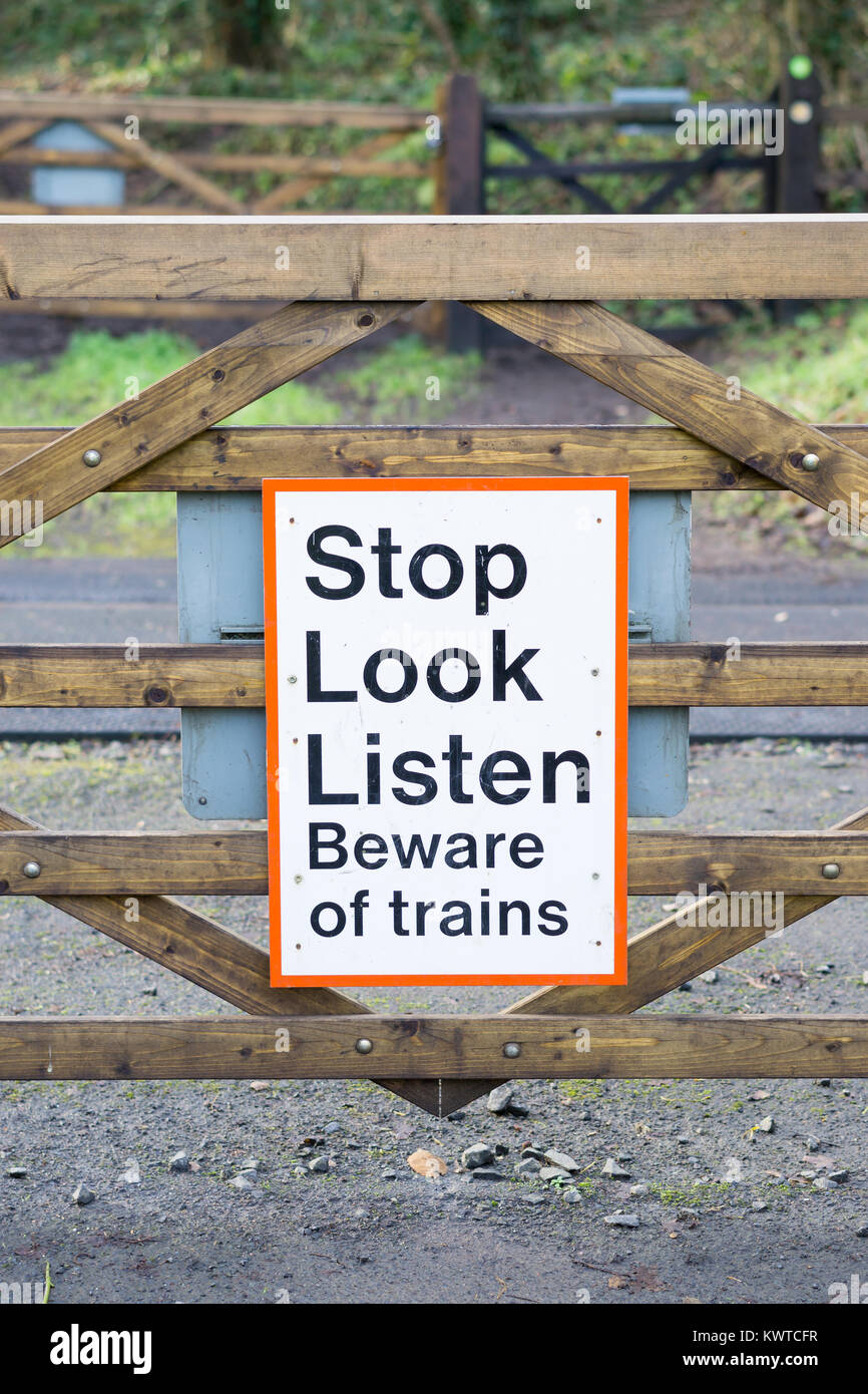 Segnale "Stop Look Listen" alla barriera del passaggio ferroviario storico. Attenzione ai pedoni per 'attenzione ai treni'. Salute e sicurezza avviso pubblico. Foto Stock