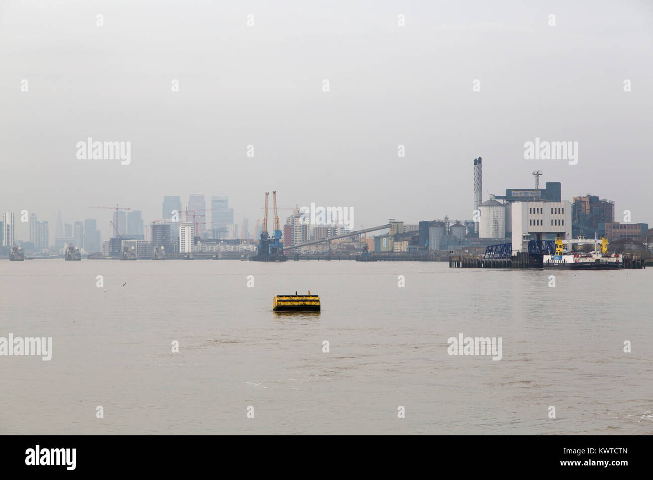 Un giorno grigio a Londra, Inghilterra. Un giallo buot galleggia sul Fiume Tamigi. Foto Stock