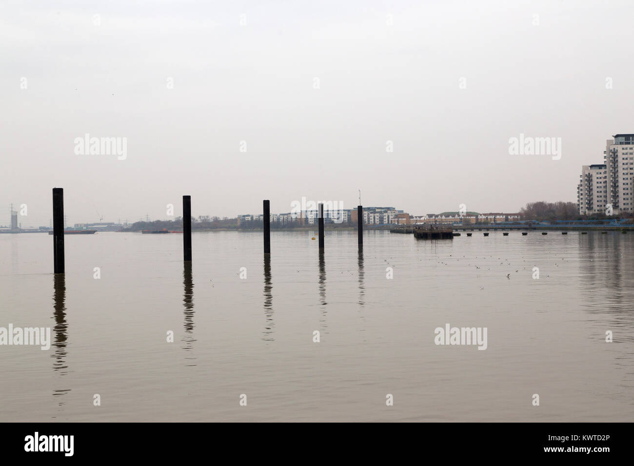 Il fiume il Tamigi a Woolwich a Londra, Inghilterra. Pile riflettono in vie navigabili. Foto Stock