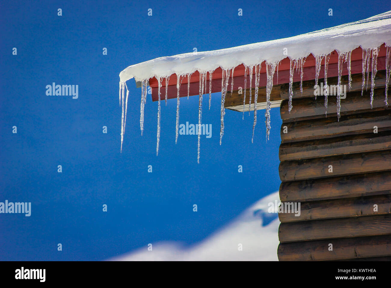 Numerosi ghiaccioli sul bordo di un tetto cabina al lago Balea, Romania Foto Stock