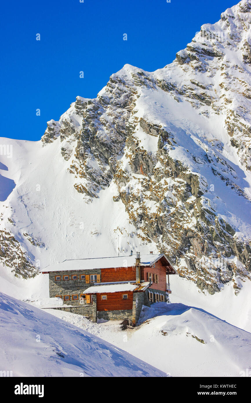 Alpine paesaggio invernale con cabina al lago Balea Fagaras e montagne coperte di neve nella contea di Sibiu, Romania Foto Stock