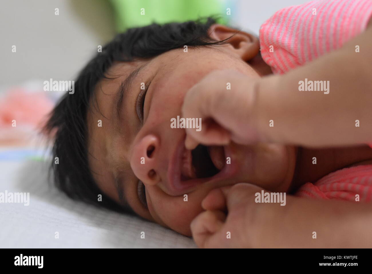 La dentizione del neonato che mostra il disagio con bocca aperta Foto Stock