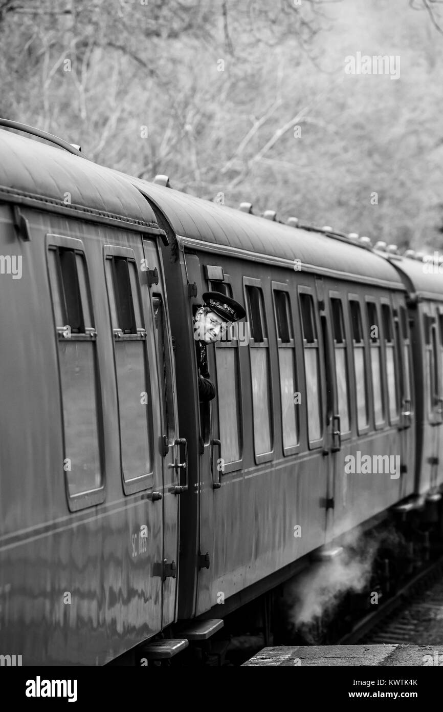 SVR locomotiva a vapore si ferma a Severn Valley Country Park fermare. Un sorridente guard guarda fuori della finestra carrello per controllare la piattaforma è chiara per andare. Foto Stock