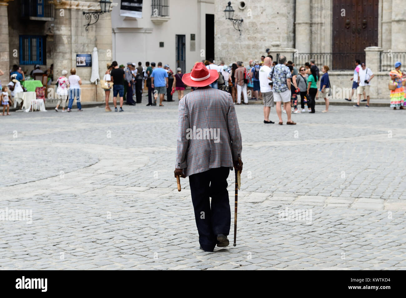 L'Avana, Cuba - 06 dicembre 2016: il residente di Havana è prima a piedi la cattedrale nel cappello e con il sigaro in mano, tra la folla di turi Foto Stock