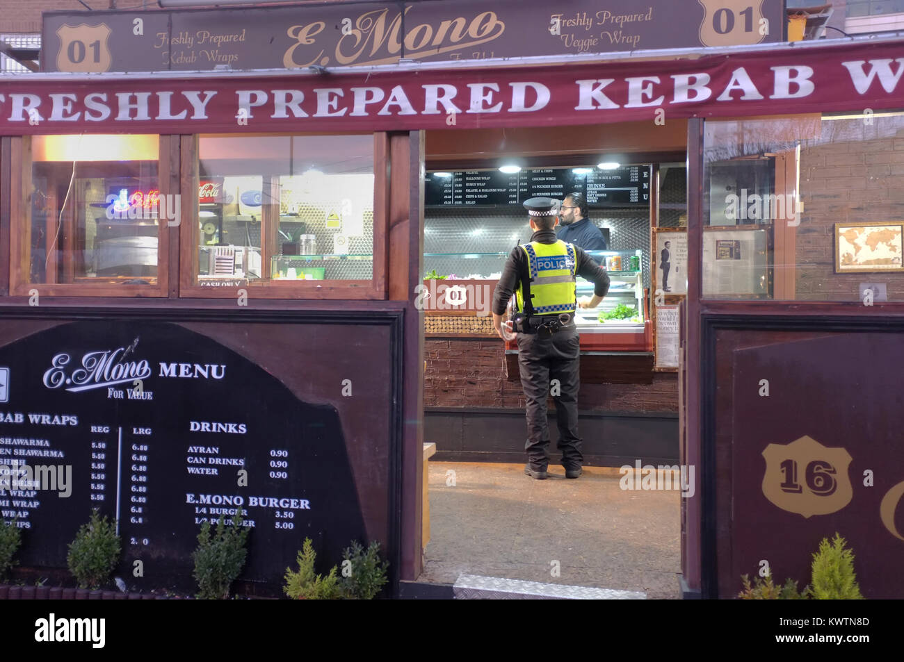 Un poliziotto comprare generi alimentari da un negozio di kebab in Londra, Regno Unito. Foto Stock