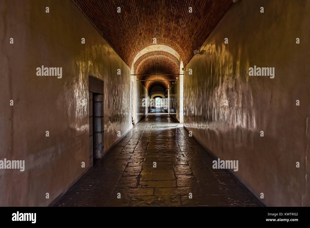 Corridoio scuro con pareti di giallo pallido in un palazzo vecchio Foto Stock