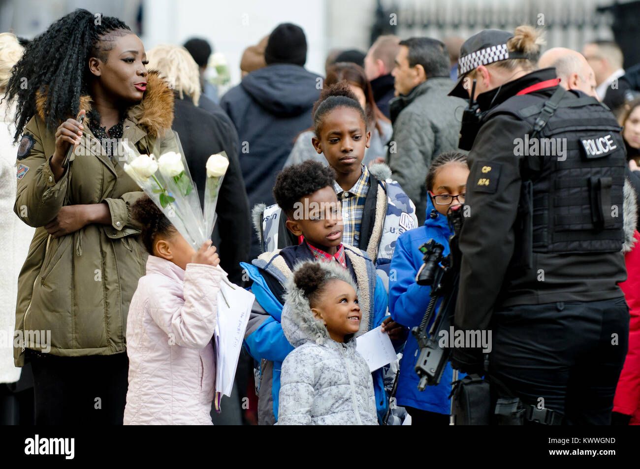 Londra, Regno Unito. Famiglia nero parlando ad una femmina di agente di polizia armato fuori dalla cattedrale di St Paul dopo un memoriale di servizio (14 Dec 2017) per l'Grenfel Foto Stock