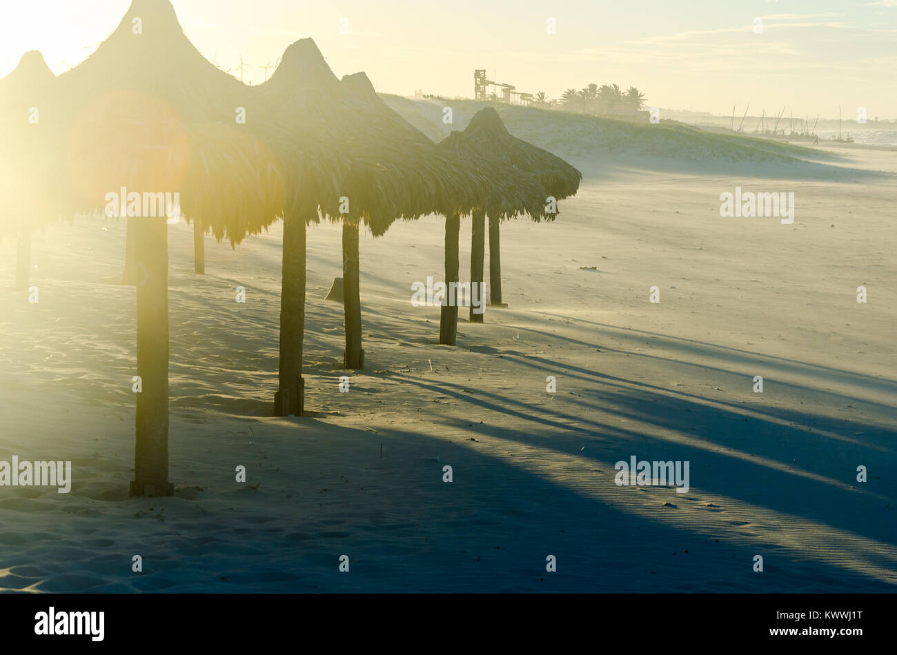 Sovraesposte spiaggia vista serale con molti ombrelloni da sole al tramonto Foto Stock