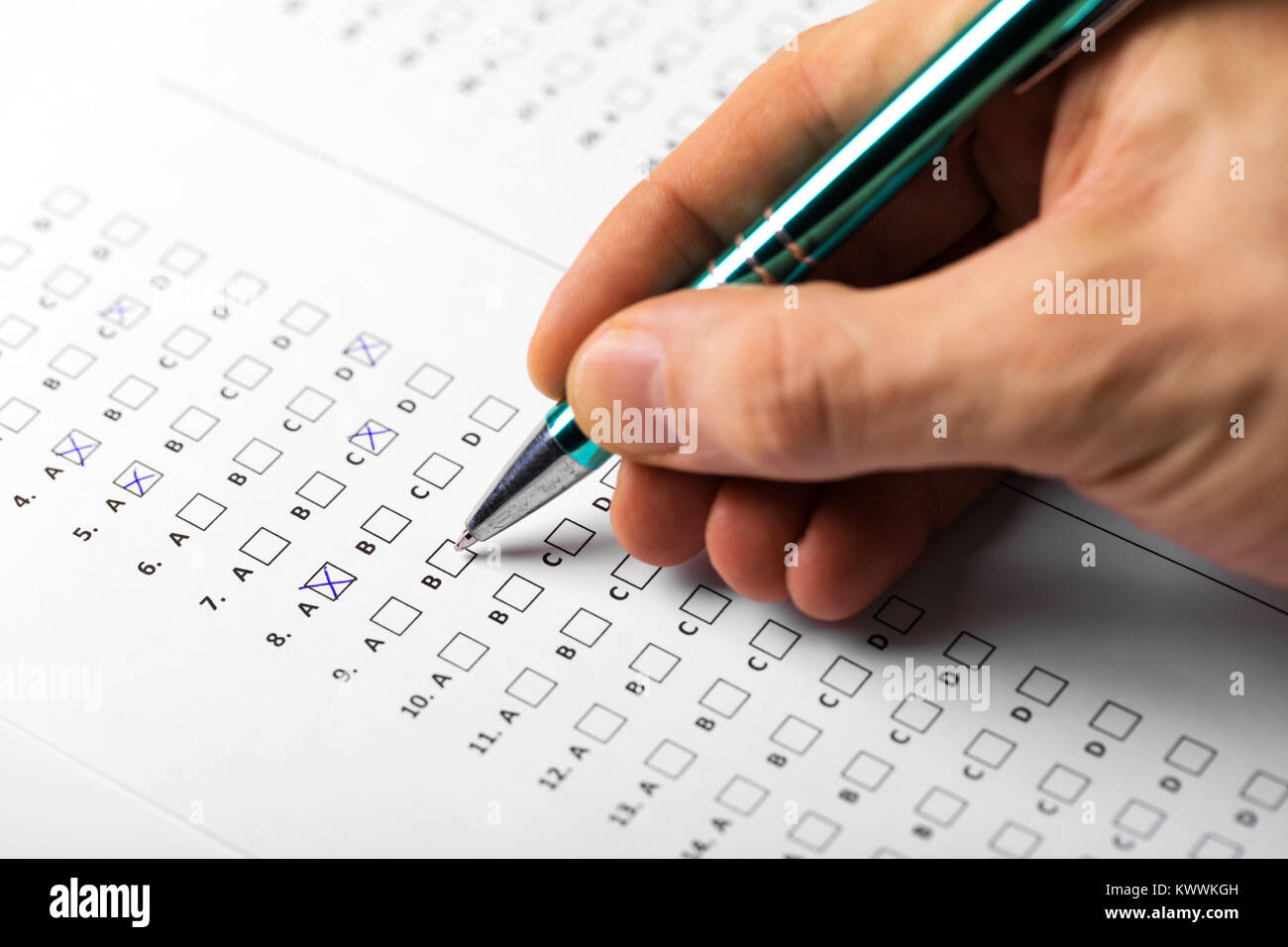 Mano dello studente con il riempimento della penna in un esame di risposta del test del foglio Foto Stock