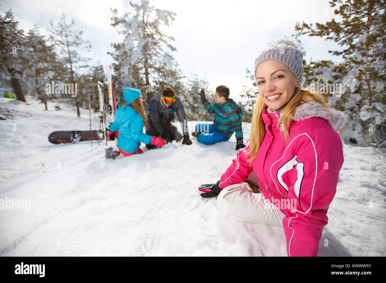 Giovane donna con la famiglia godendo sulla neve di sci Foto Stock