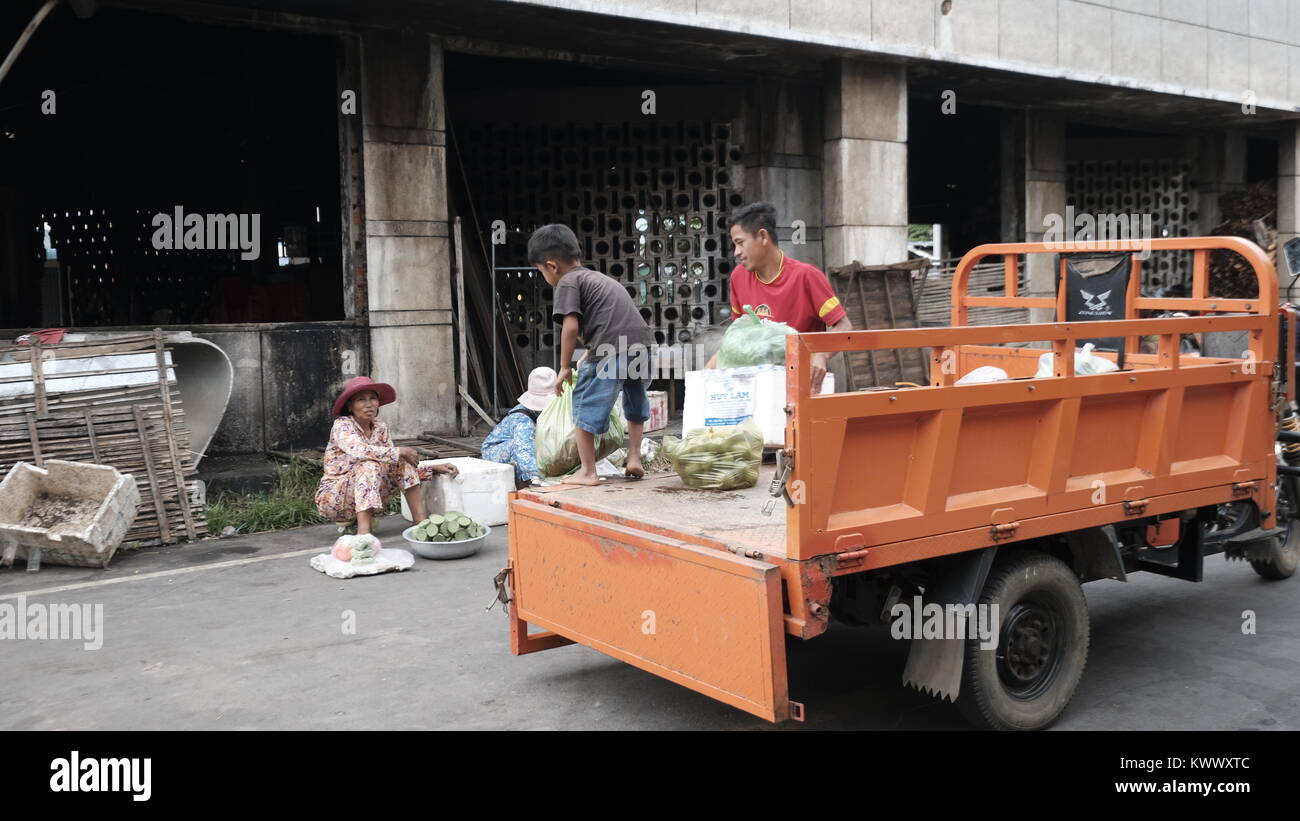 Camion arancione il lavoro minorile lo scarico di Takeo, Cambogia Mercato Centrale decrepita Terzo mondo paese sottosviluppato Sud Est Asiatico invisibile e dimenticato Foto Stock