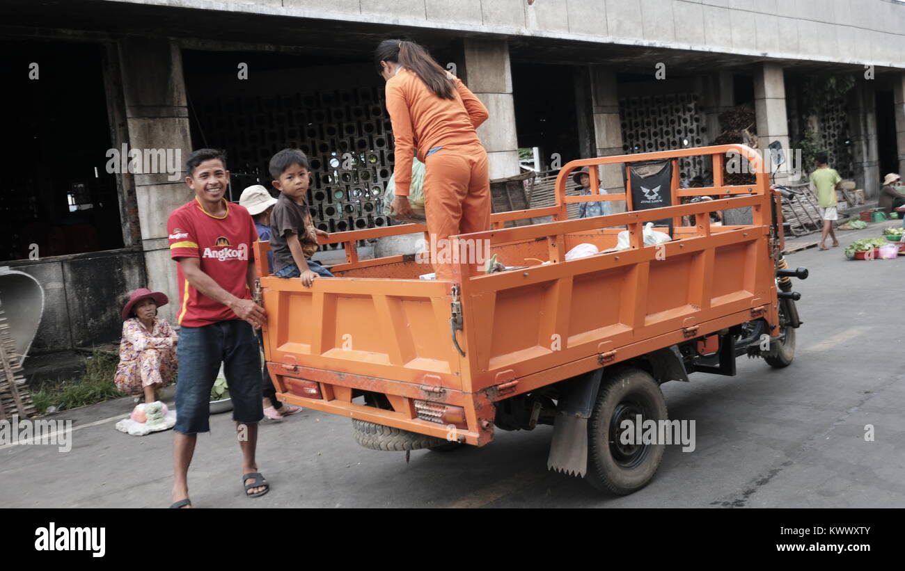 Camion arancione il lavoro minorile lo scarico di Takeo, Cambogia Mercato Centrale decrepita Terzo mondo paese sottosviluppato Sud Est Asiatico invisibile e dimenticato Foto Stock
