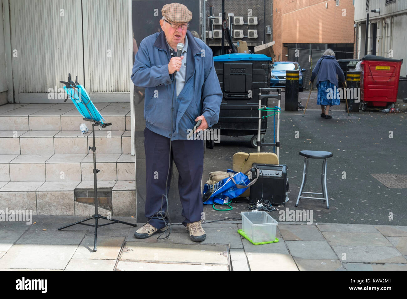 Un uomo maturo cantando per carità nel centro cittadino di Newcastle. Foto Stock