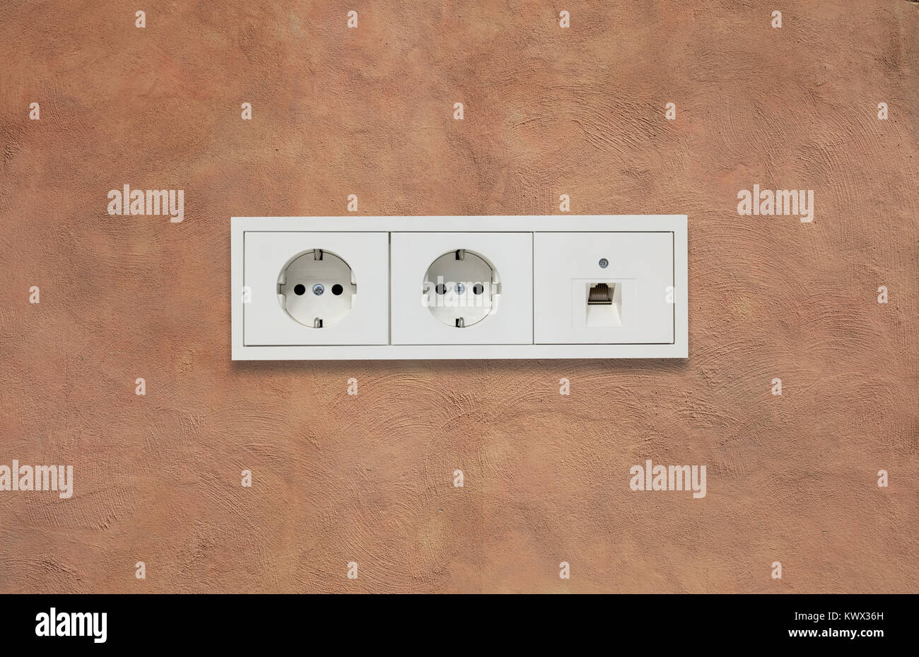 Doppie moderne prese elettriche e la linea di rete. Marrone chiaro parete in stucco sullo sfondo. Closeup, dettagli. Foto Stock