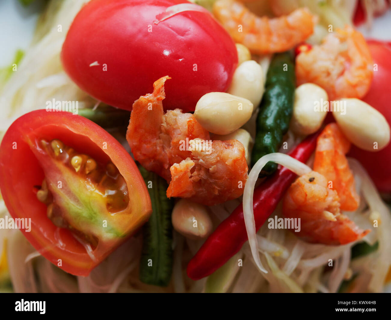 Thai papaia verde insalata, Som Tam, famosa cucina di strada di Thailandia a floreali tradizionale vassoio di stampa in close up shot su viola Thai sfondo perizoma Foto Stock