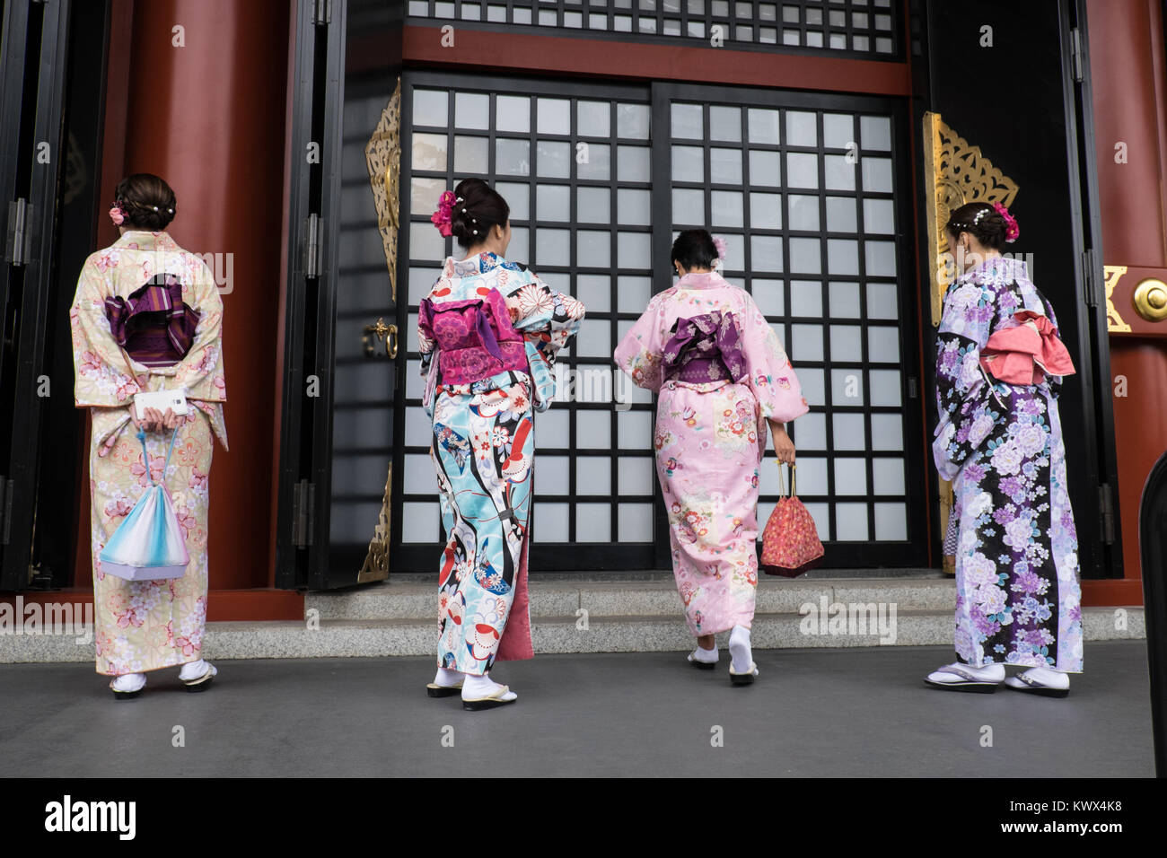 Giappone Tokyo, isola di Honshu: turisti indossando il tradizionale giapponese vestiti, qui di fronte a una porta del tempio Senso-Ji, nel quartiere di Asakusa Foto Stock