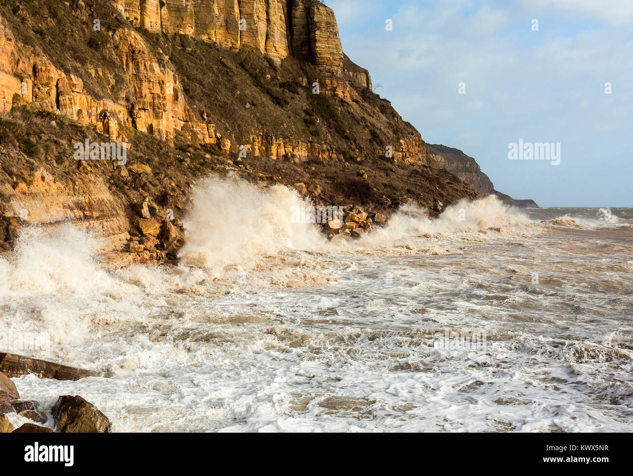 Tempesta di marea pounding in arenaria Oriente scogliere a Hastings. Foto Stock