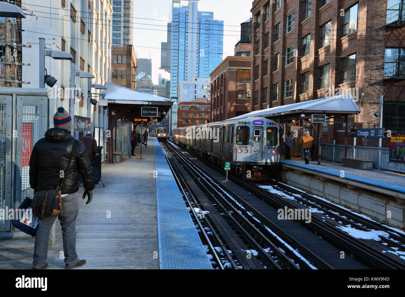 I passeggeri di attendere per il loro treno nel freddo presso il Chicago Avenue L stazione sul vicino lato nord di Chicago. Foto Stock