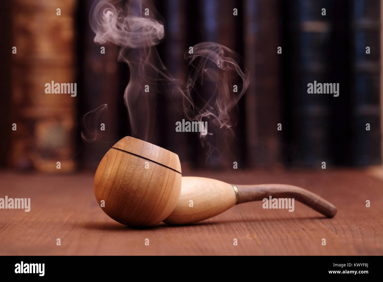 Il tabacco da fumo tubo su sfondo di legno con libri antichi Foto Stock