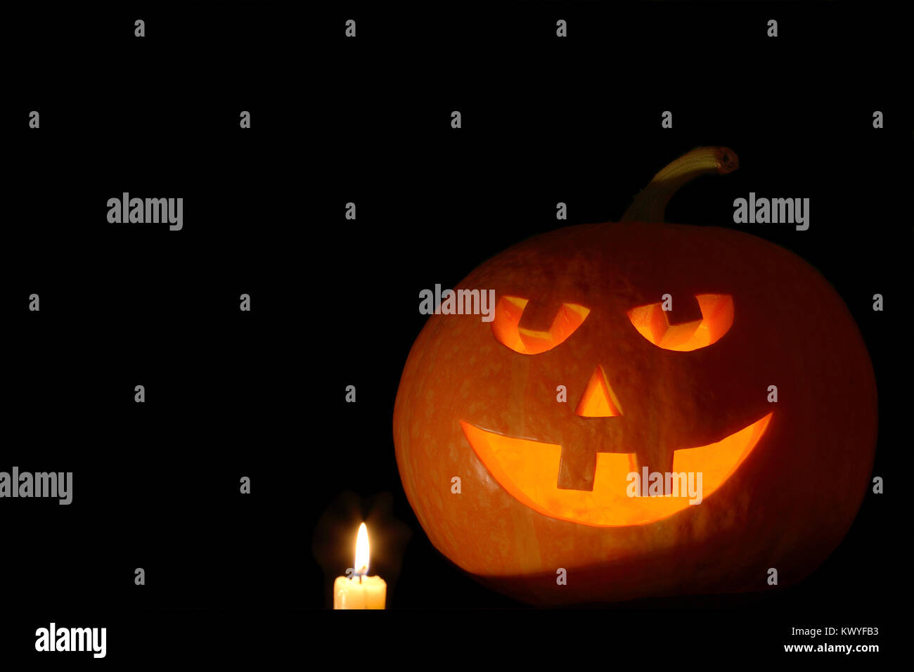 Primo piano della testa di zucca isolati su sfondo nero con illuminazione candela Foto Stock